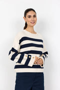 Woman wearing a navy and white striped sweater with button details on a white background